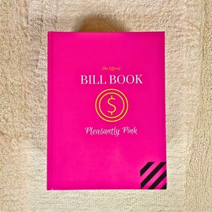 May include: A hot pink "Bill Book" with the text "The Official BILL BOOK" and "Pleasantly Pink". A yellow dollar sign is in the center. Black and white diagonal stripes are in the bottom right corner.