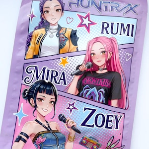 Könnte beinhalten: Eine lila Verpackung mit drei Illustrationen im Anime-Stil von Frauen, die jeweils ein Mikrofon halten. Die Verpackung ist mit "HUNTRAX" und den Namen "RUMI", "MIRA" und "ZOEY" darunter beschriftet. Dekorative Sterne und Herzen sind ebenfalls enthalten.