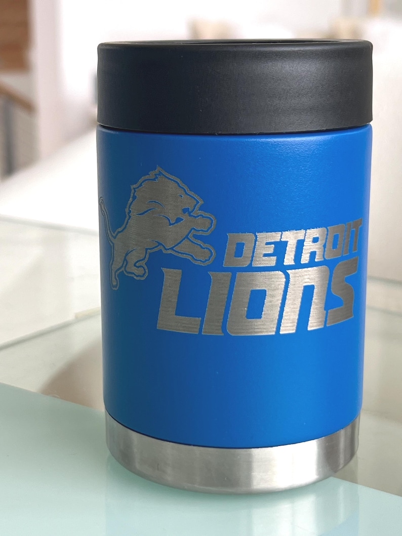 Show your football pride and keep your favorite drink ice cold with this Detroit Lions-inspired 12 oz insulated bottle cooler. Featuring a laser-engraved design on a durable, powder-coated blue finish, it combines style, function, and team spirit in one premium game day accessory. The double-wall stainless steel insulation keeps drinks at the perfect temperature longer, making it ideal for tailgates, backyard barbecues, camping trips, man caves, or just relaxing while watching the big game.