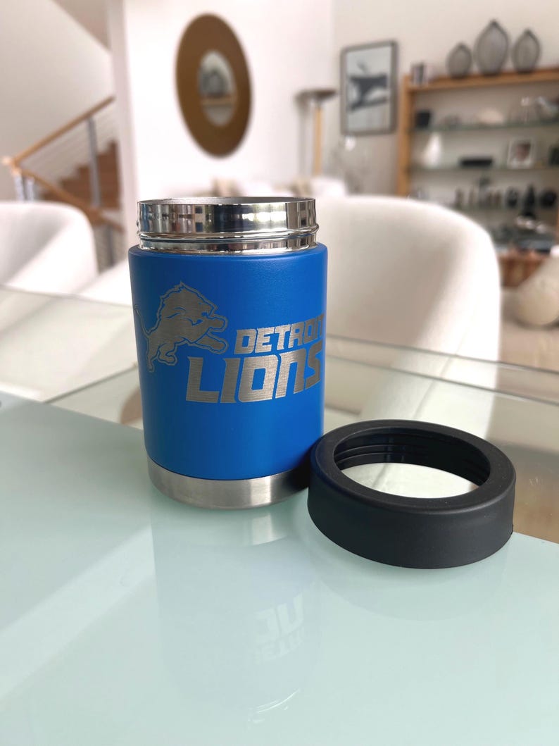 Show your football pride and keep your favorite drink ice cold with this Detroit Lions-inspired 12 oz insulated bottle cooler. Featuring a laser-engraved design on a durable, powder-coated blue finish, it combines style, function, and team spirit in one premium game day accessory. The double-wall stainless steel insulation keeps drinks at the perfect temperature longer, making it ideal for tailgates, backyard barbecues, camping trips, man caves, or just relaxing while watching the big game.
