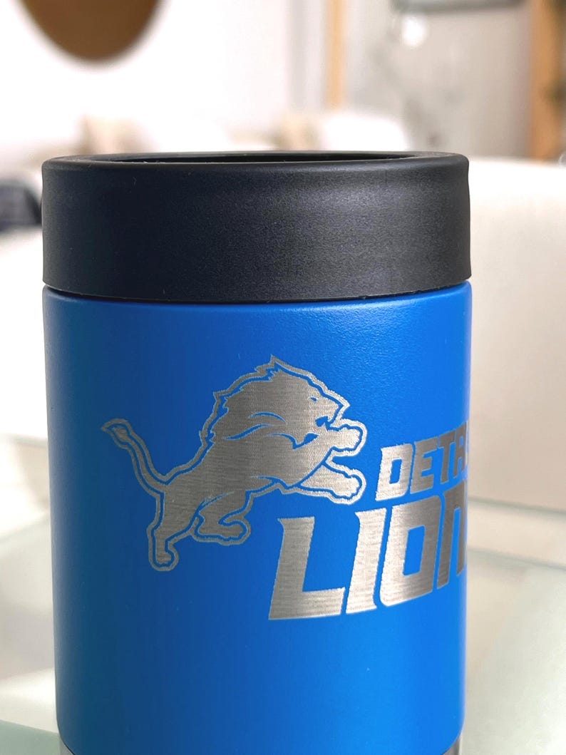 Show your football pride and keep your favorite drink ice cold with this Detroit Lions-inspired 12 oz insulated bottle cooler. Featuring a laser-engraved design on a durable, powder-coated blue finish, it combines style, function, and team spirit in one premium game day accessory. The double-wall stainless steel insulation keeps drinks at the perfect temperature longer, making it ideal for tailgates, backyard barbecues, camping trips, man caves, or just relaxing while watching the big game.