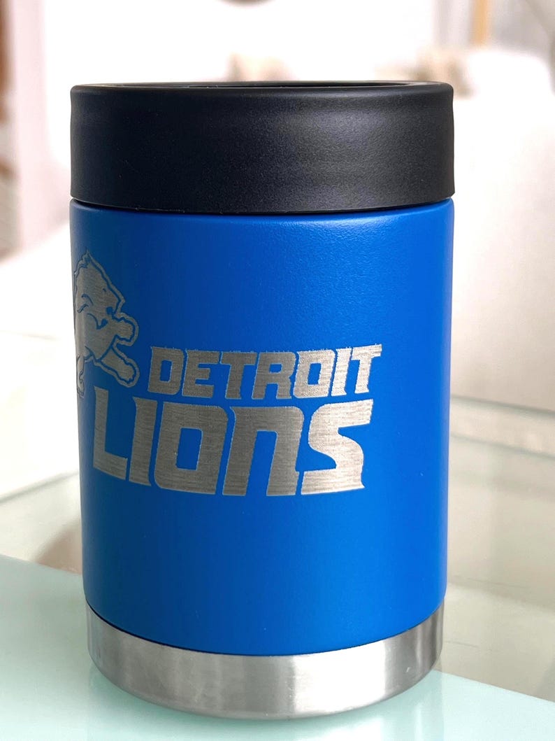 Show your football pride and keep your favorite drink ice cold with this Detroit Lions-inspired 12 oz insulated bottle cooler. Featuring a laser-engraved design on a durable, powder-coated blue finish, it combines style, function, and team spirit in one premium game day accessory. The double-wall stainless steel insulation keeps drinks at the perfect temperature longer, making it ideal for tailgates, backyard barbecues, camping trips, man caves, or just relaxing while watching the big game.