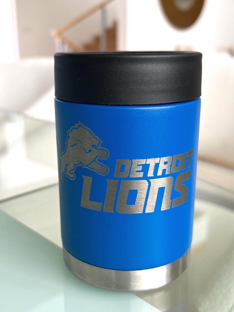 Show your football pride and keep your favorite drink ice cold with this Detroit Lions-inspired 12 oz insulated bottle cooler. Featuring a laser-engraved design on a durable, powder-coated blue finish, it combines style, function, and team spirit in one premium game day accessory. The double-wall stainless steel insulation keeps drinks at the perfect temperature longer, making it ideal for tailgates, backyard barbecues, camping trips, man caves, or just relaxing while watching the big game.