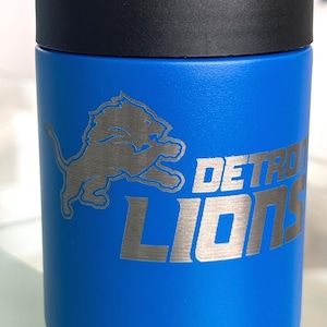 Show your football pride and keep your favorite drink ice cold with this Detroit Lions-inspired 12 oz insulated bottle cooler. Featuring a laser-engraved design on a durable, powder-coated blue finish, it combines style, function, and team spirit in one premium game day accessory. The double-wall stainless steel insulation keeps drinks at the perfect temperature longer, making it ideal for tailgates, backyard barbecues, camping trips, man caves, or just relaxing while watching the big game.