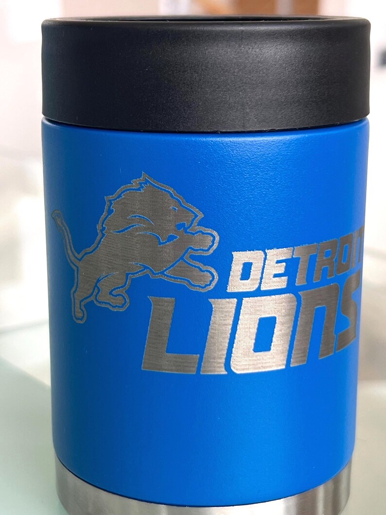 Show your football pride and keep your favorite drink ice cold with this Detroit Lions-inspired 12 oz insulated bottle cooler. Featuring a laser-engraved design on a durable, powder-coated blue finish, it combines style, function, and team spirit in one premium game day accessory. The double-wall stainless steel insulation keeps drinks at the perfect temperature longer, making it ideal for tailgates, backyard barbecues, camping trips, man caves, or just relaxing while watching the big game.