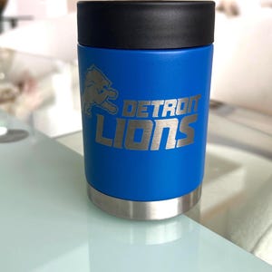 Show your football pride and keep your favorite drink ice cold with this Detroit Lions-inspired 12 oz insulated bottle cooler. Featuring a laser-engraved design on a durable, powder-coated blue finish, it combines style, function, and team spirit in one premium game day accessory. The double-wall stainless steel insulation keeps drinks at the perfect temperature longer, making it ideal for tailgates, backyard barbecues, camping trips, man caves, or just relaxing while watching the big game.
