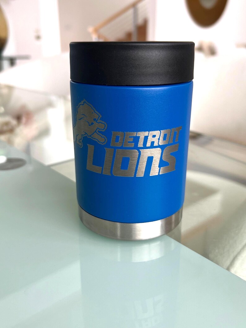 Show your football pride and keep your favorite drink ice cold with this Detroit Lions-inspired 12 oz insulated bottle cooler. Featuring a laser-engraved design on a durable, powder-coated blue finish, it combines style, function, and team spirit in one premium game day accessory. The double-wall stainless steel insulation keeps drinks at the perfect temperature longer, making it ideal for tailgates, backyard barbecues, camping trips, man caves, or just relaxing while watching the big game.