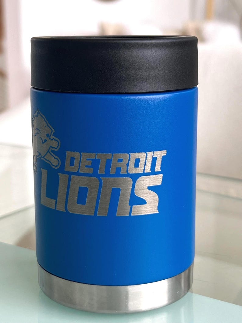 Show your football pride and keep your favorite drink ice cold with this Detroit Lions-inspired 12 oz insulated bottle cooler. Featuring a laser-engraved design on a durable, powder-coated blue finish, it combines style, function, and team spirit in one premium game day accessory. The double-wall stainless steel insulation keeps drinks at the perfect temperature longer, making it ideal for tailgates, backyard barbecues, camping trips, man caves, or just relaxing while watching the big game.