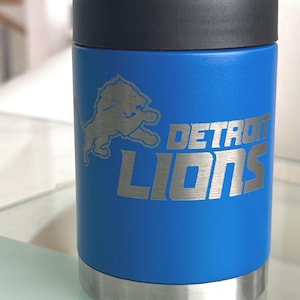 Show your football pride and keep your favorite drink ice cold with this Detroit Lions-inspired 12 oz insulated bottle cooler. Featuring a laser-engraved design on a durable, powder-coated blue finish, it combines style, function, and team spirit in one premium game day accessory. The double-wall stainless steel insulation keeps drinks at the perfect temperature longer, making it ideal for tailgates, backyard barbecues, camping trips, man caves, or just relaxing while watching the big game.