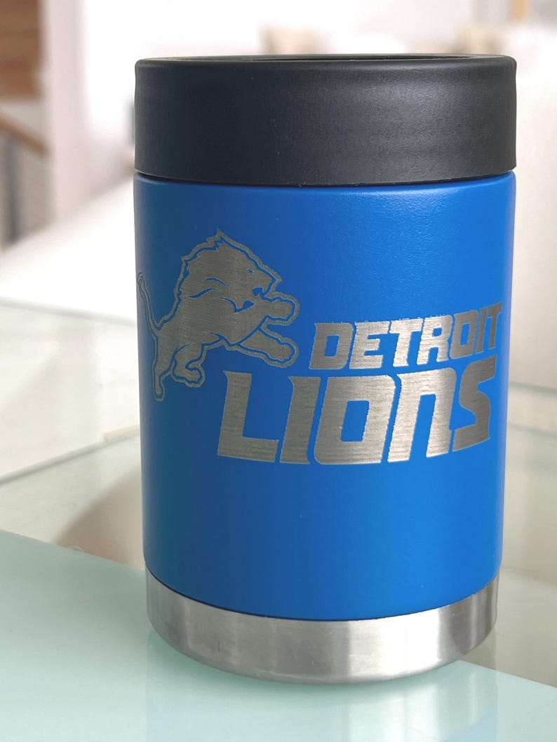 Show your football pride and keep your favorite drink ice cold with this Detroit Lions-inspired 12 oz insulated bottle cooler. Featuring a laser-engraved design on a durable, powder-coated blue finish, it combines style, function, and team spirit in one premium game day accessory. The double-wall stainless steel insulation keeps drinks at the perfect temperature longer, making it ideal for tailgates, backyard barbecues, camping trips, man caves, or just relaxing while watching the big game.