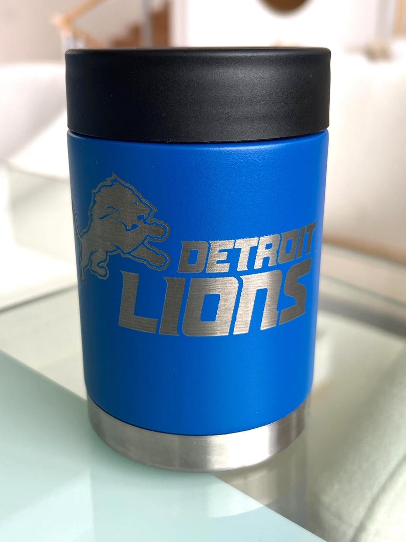 Show your football pride and keep your favorite drink ice cold with this Detroit Lions-inspired 12 oz insulated bottle cooler. Featuring a laser-engraved design on a durable, powder-coated blue finish, it combines style, function, and team spirit in one premium game day accessory. The double-wall stainless steel insulation keeps drinks at the perfect temperature longer, making it ideal for tailgates, backyard barbecues, camping trips, man caves, or just relaxing while watching the big game.