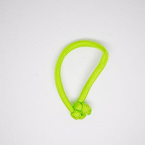 May include: A bright green rope loop with a knot at the bottom. The rope is thick and woven. The background is plain white.
