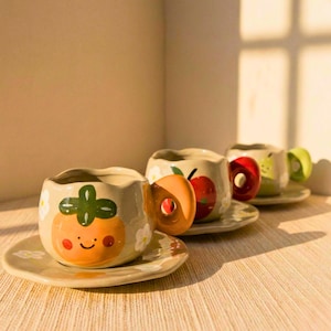 May include: A set of three ceramic mugs with a speckled, matte finish in cream, light grey, and dark grey. Each mug has a simple, minimalist design, suitable for coffee or tea.