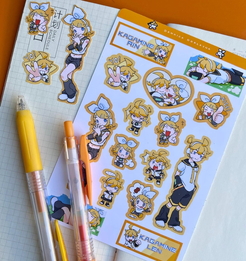 May include: A collection of anime-style stickers featuring characters with yellow hair and blue bows. The stickers are on a white background with text that reads "Kagamine Rin" and "Kagamine Len". Two yellow pens are in the foreground.