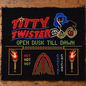 May include: A black cross-stitch embroidery on fabric featuring the red text TITTY TWISTER, blue hair graphic, and green text OPEN DUSK TILL DAWN. Below are two flaming torches, the red text HOT HOT HOT, a central arch, and blue text DANCING CHICAS.