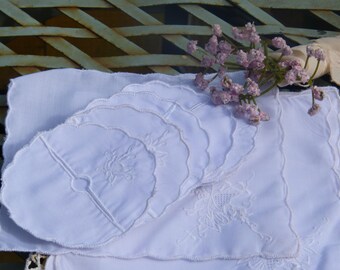 Juego de diez servilletas de cóctel bordadas y diez fundas para botellas de vino a juego, también bordadas.