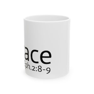 May include: A white ceramic mug featuring black text printed on the side. The text reads Grace followed by the scripture reference Eph. 2:8-9. The mug has a cylindrical shape with a smooth finish and a simple, clean design for daily beverage use.