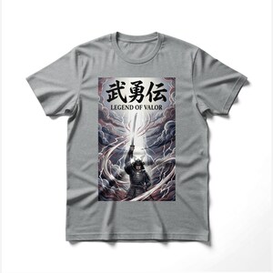 Peut inclure: T-shirt gris avec un graphisme de samouraï brandissant une épée. Le motif comprend des caractères japonais et le texte anglais "LEGEND OF VALOR" sur fond de nuages orageux et d'éclairs.