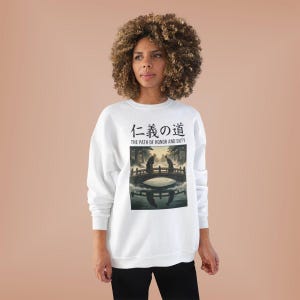 Pode incluir: Camisola branca com um gráfico de uma cena de ponte e texto japonês. O texto diz "O Caminho da Honra e do Dever". Uma peça de roupa casual e confortável.