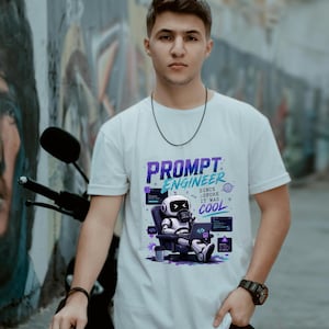May include: White t-shirt with a graphic that reads "PROMPT ENGINEER" in purple and blue. The graphic features a robot sitting in a chair with a laptop. The text "SINCE BEFORE IT WAS COOL" is also included.
