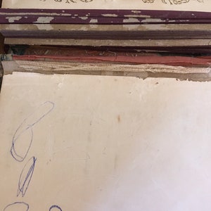 Puede incluir: Primer plano de una p&aacute;gina blanca en blanco con garabatos de l&aacute;piz azul. La p&aacute;gina es parte de un &aacute;lbum de fotos vintage con una cubierta de cuero marr&oacute;n.