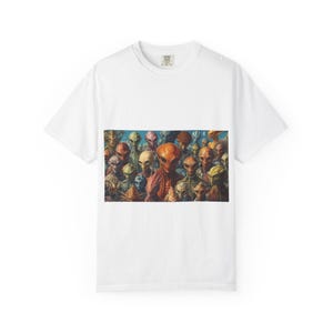 Puede incluir: Camiseta blanca con un gráfico colorido de varias especies alienígenas. Los alienígenas tienen diversos tonos de piel, incluyendo naranja, verde y gris. La obra de arte es detallada, con cada alienígena con rasgos únicos. La camiseta está hecha de un material suave.