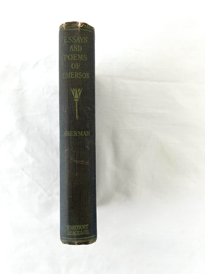 May include: A black hardcover book with gold lettering. The title is "Essays and Poems of Emerson" by Sherman. The book is published by Harcourt, Brace & Co.