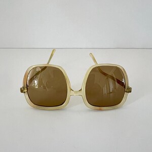 K&ouml;nnte beinhalten: Handgefertigtes Holzschild mit dem Wort "Willkommen" in verspielter Schrift. Es hat einen wei&szlig;en, abgenutzten Hintergrund und einen dunkel gebeizten Holzrahmen. Ein dekoratives Blumenelement ist vorhanden.