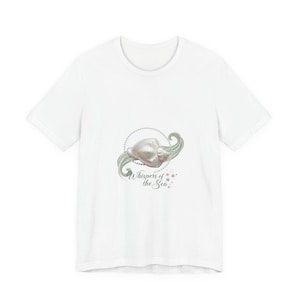 以下が含まれることがあります： 白いTシャツ。貝殻のデザインと「Whispers of the Sea」の文字。デザインには、真珠のネックレス、渦巻く緑色のアクセント、星のディテールが含まれています。カジュアルな普段着です。