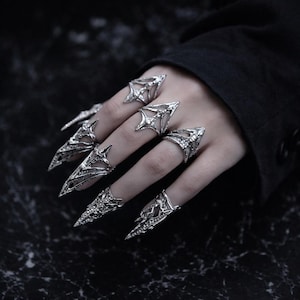 Könnte beinhalten: Eine weiße Keramik-Tasse mit schwarzem Henkel und dem Text "But First, Coffee" in schwarzer, handschriftlicher Schrift. Die Tasse steht auf einer weißen Oberfläche.