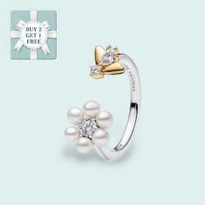 Op de afbeelding: Zilveren ring met een bloem- en vlindermotief. De bloem is gemaakt van witte parels en een centrale heldere steen. De vlinder heeft goudkleurige vleugels en heldere steendetails. De ring is gegraveerd met het woord "PANDORA".