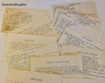May include: A collection of vintage recipe cards with handwritten instructions for various dishes, including guacamole, Irish stew, corn pudding, and baked clams. The cards are yellowed with age and have a rustic charm.