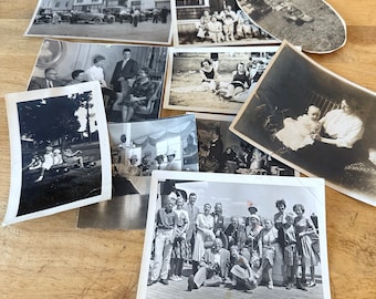 May include: A collection of vintage black and white photographs featuring various scenes including a street with cars, a group on a beach, a family portrait, children in a wagon, and a large group of people posing together on a deck.