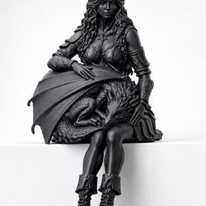 May include: A matte black figurine depicting a long-haired figure in armored attire sitting down while cradling a small dragon with textured scales. The figure wears detailed shoulder guards, a bodice, and lace-up boots, with the dragon resting on their lap.