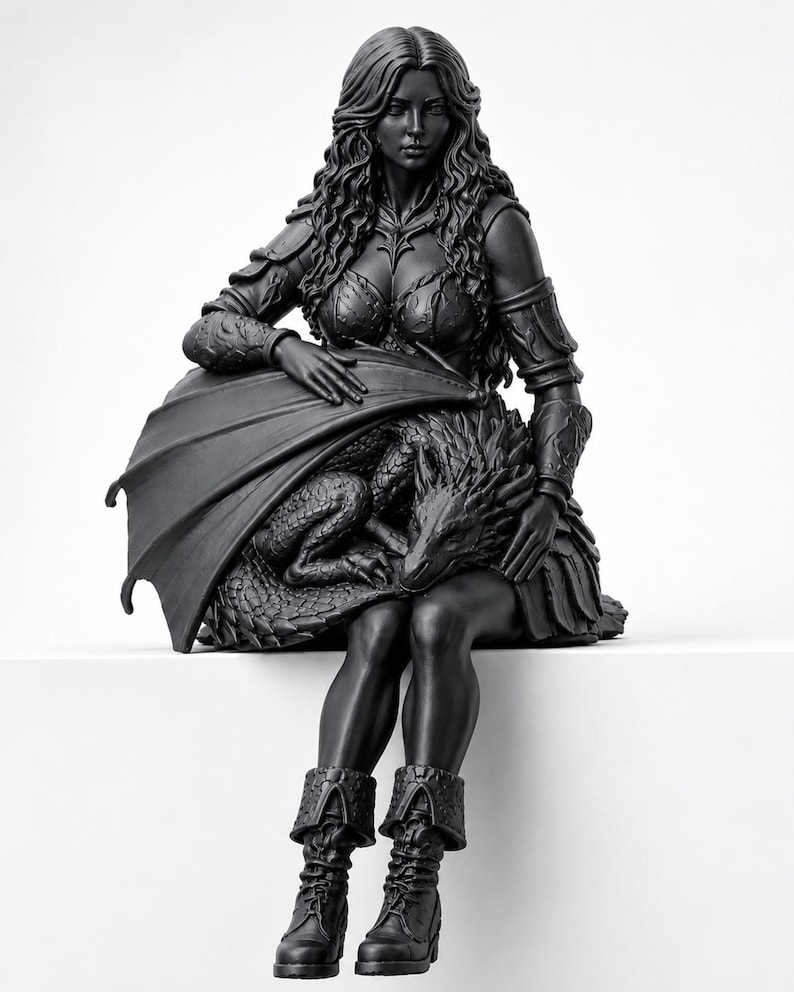 May include: A matte black figurine depicting a long-haired figure in armored attire sitting down while cradling a small dragon with textured scales. The figure wears detailed shoulder guards, a bodice, and lace-up boots, with the dragon resting on their lap.