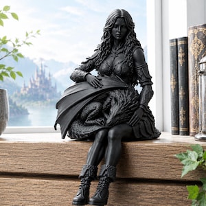May include: A matte black figurine depicting a long-haired figure in armor and boots sitting while cradling a dragon with folded wings. The sculpture features intricate textures on the dragon scales and the figure's attire, rendered in a solid dark tone.