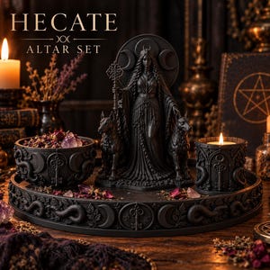 May include: A black Hecate altar set featuring a central statue of a figure with two dogs, a circular tray, a bowl, and a candle holder. The items are decorated with moon, key, and snake motifs. The text HECATE ALTAR SET is visible at the top.