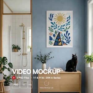 Puede incluir: Una lámina de arte mural vertical enmarcada con un sol amarillo, follaje abstracto azul y verde, y un camino central oscuro con formas coloridas. La obra se exhibe en una pared azul sobre un mueble de madera clara con un gato negro encima.