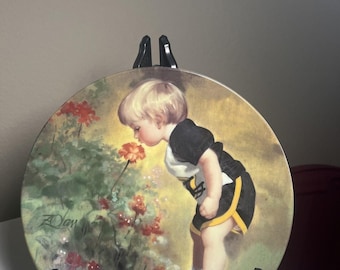 Plato decorativo vintage de Donald Zolan “El jardín de la abuela” con la imagen de un niño pequeño.