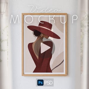 Può includere: Una cornice rettangolare in legno contenente l'illustrazione di una persona vista di spalle, che indossa un cappello a tesa larga rosso scuro e un abito a maniche lunghe abbinato. Il testo Video MOCKUP è in alto e un logo Ps PSD in basso.