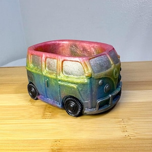 May include: A white ceramic mug with a black handle and the text "But First, Coffee" in a black, handwritten-style font. The mug is on a white surface.