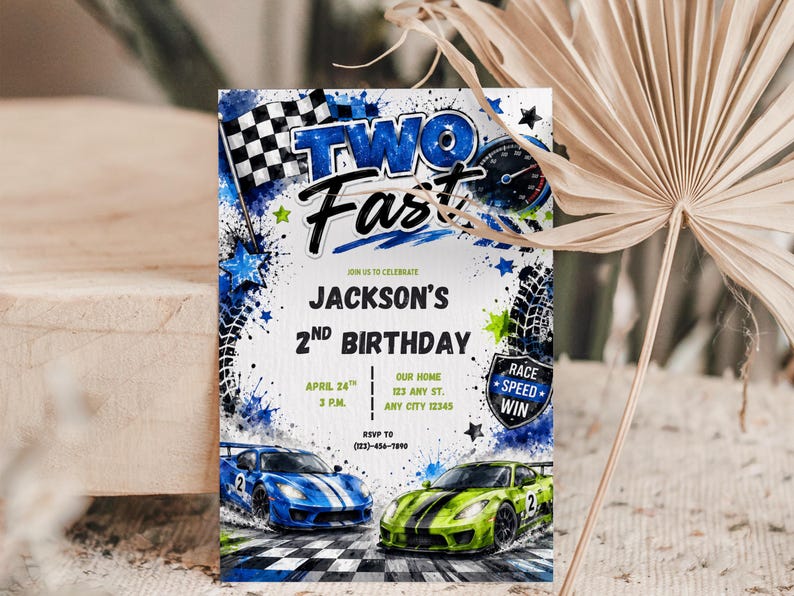 May include: A rectangular birthday invitation card featuring a blue and green race car theme with a checkered flag, speedometer, and tire tracks. The text reads TWO FAST, JACKSON'S 2ND BIRTHDAY, APRIL 24TH, 3 P.M., OUR HOME, 123 ANY ST., ANY CITY 12345, and RSVP TO (123)-456-7890.