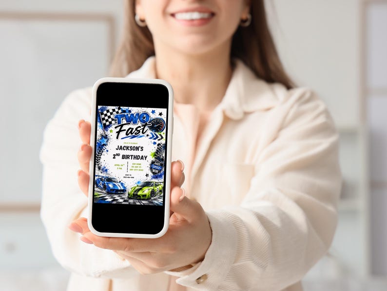 May include: A smartphone screen displaying a digital birthday invitation with the text TWO FAST, JACKSON'S 2ND BIRTHDAY. The design features blue and green race cars, checkered flags, tire tracks, and a speedometer graphic on a white background.