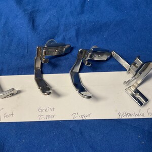 Peut inclure: Quatre pieds de machine &agrave; coudre&nbsp;: un pied de feston pour cordon argent&eacute;, un pied de fermeture &eacute;clair greist argent&eacute;, un pied de fermeture &eacute;clair argent&eacute; et un pied de boutonni&egrave;re argent&eacute;.