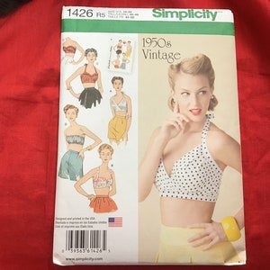 May include: Simplicity sewing pattern number 1426, for a 1950s vintage halter top. The pattern includes four different styles of halter tops, with one model wearing a white halter top with black polka dots. The pattern is designed and printed in the USA.