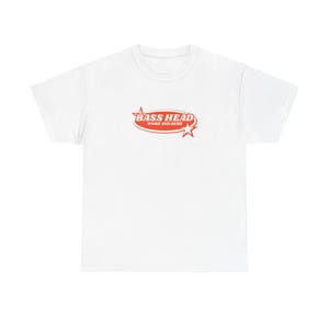 May include: A white short-sleeve t-shirt featuring a centered red graphic. The design consists of an oval shape containing the text BASS HEAD in bold letters, with the words WUBZ AND DUBZ underneath, flanked by two four-pointed star icons.