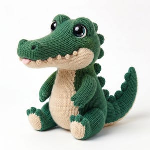May include: A knitted alligator toy in shades of green and beige, with large, shiny eyes and a pink tongue. The plush toy is sitting, displaying its textured knit pattern and friendly design. A soft, cuddly toy.