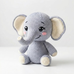 Peut inclure: Une peluche éléphant grise tricotée avec de grands yeux noirs, des joues roses et des oreilles intérieures crème. L'éléphant est assis, sa trompe levée, avec des accents crème sur les pieds et la trompe.