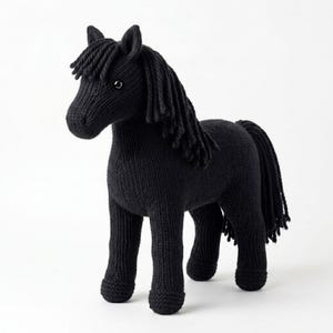 May include: A black knitted horse figurine with a flowing mane and tail. The horse has a detailed, textured appearance, with visible stitch patterns. The toy horse stands on four legs and has a small, round eye.