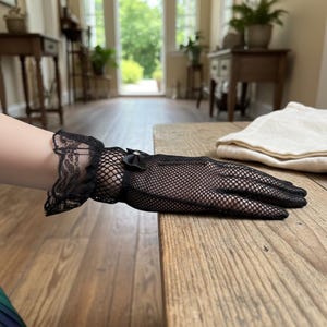 Puede incluir: Una taza de cerámica blanca con un asa negra y el texto "But First, Coffee" en un estilo manuscrito. La taza está sobre una superficie blanca. La taza mide aproximadamente 10 cm de alto.